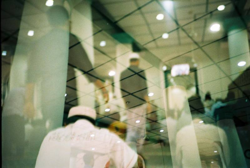 double exposure image of men in mosque